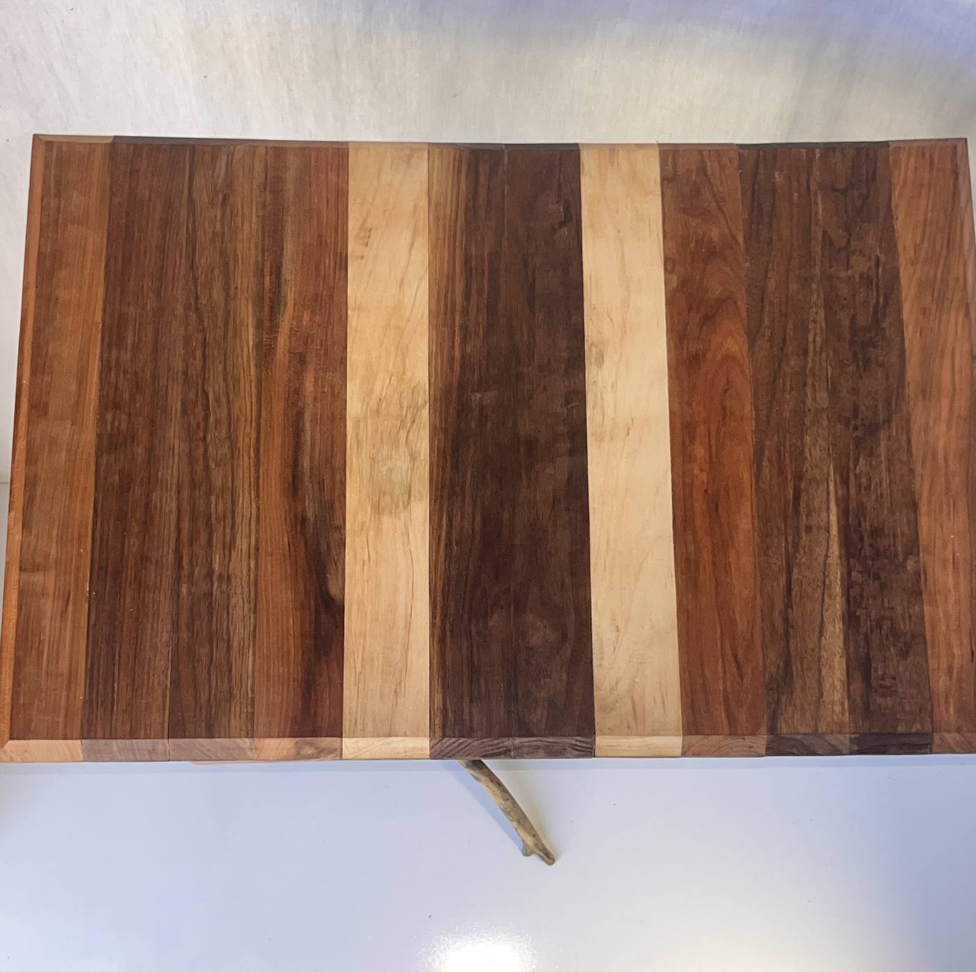 The tabletop from above, banded in alternating light and dark hardwood.